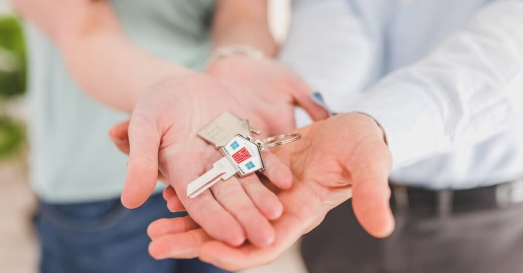 Close-up of a couple holding keys, symbolizing homeownership and investment.