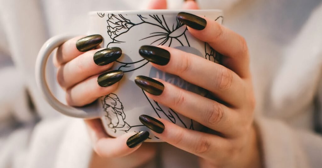 A close-up of manicured hands holding a decorative mug, perfect for lifestyle and coffee themes.