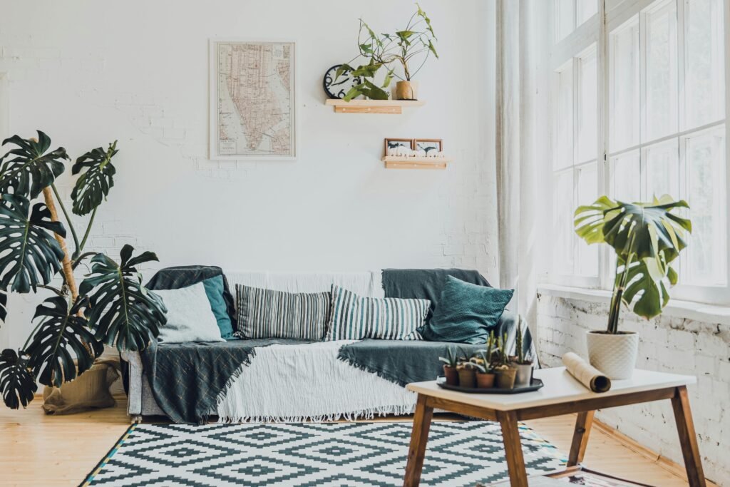 Bright living room with Scandinavian design, featuring plants and a cozy sofa.